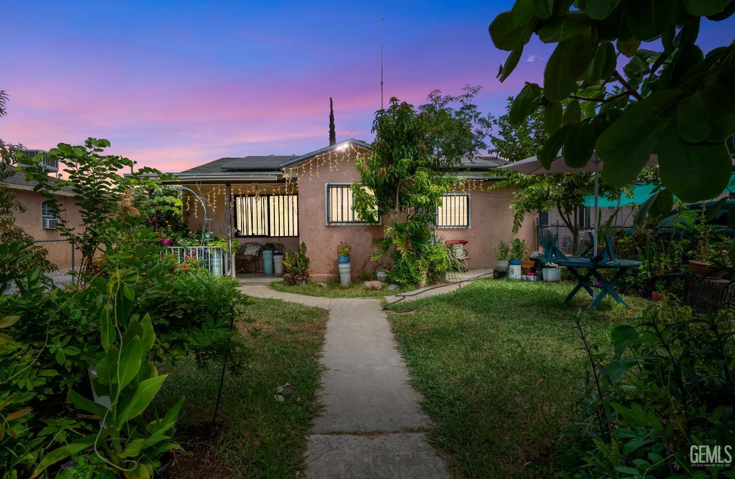 a front view of a house with a yard and potted plants