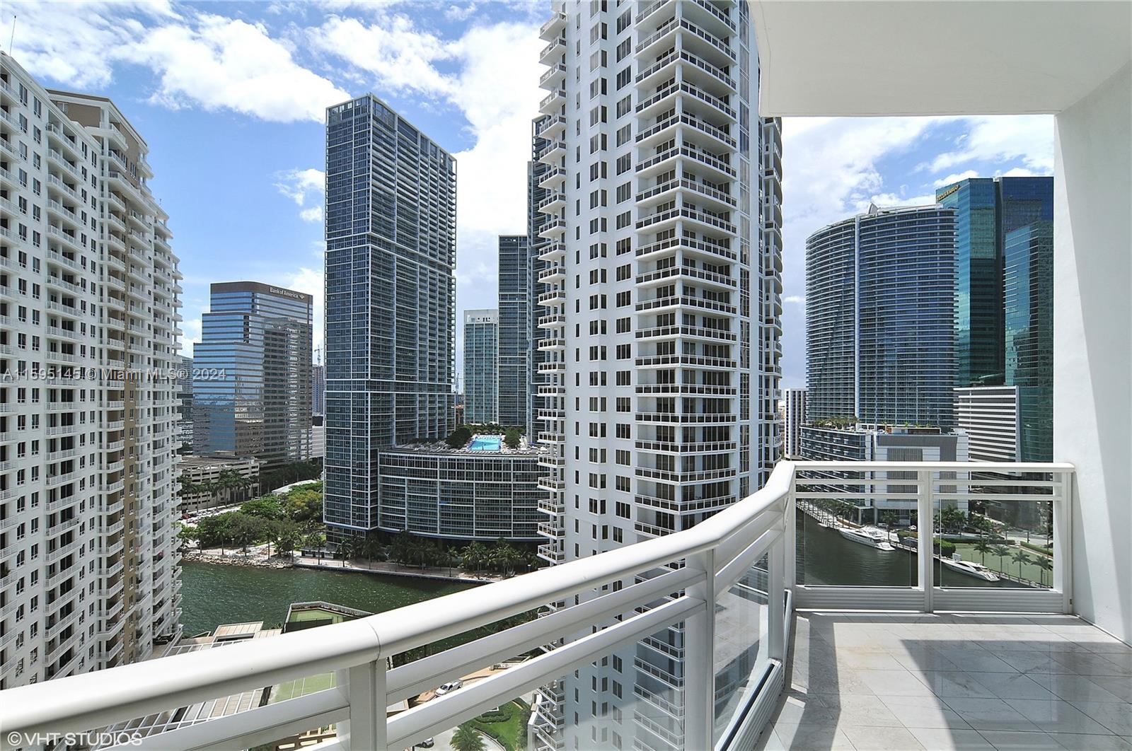 a view of balcony with a couple of cars parked in front of a house