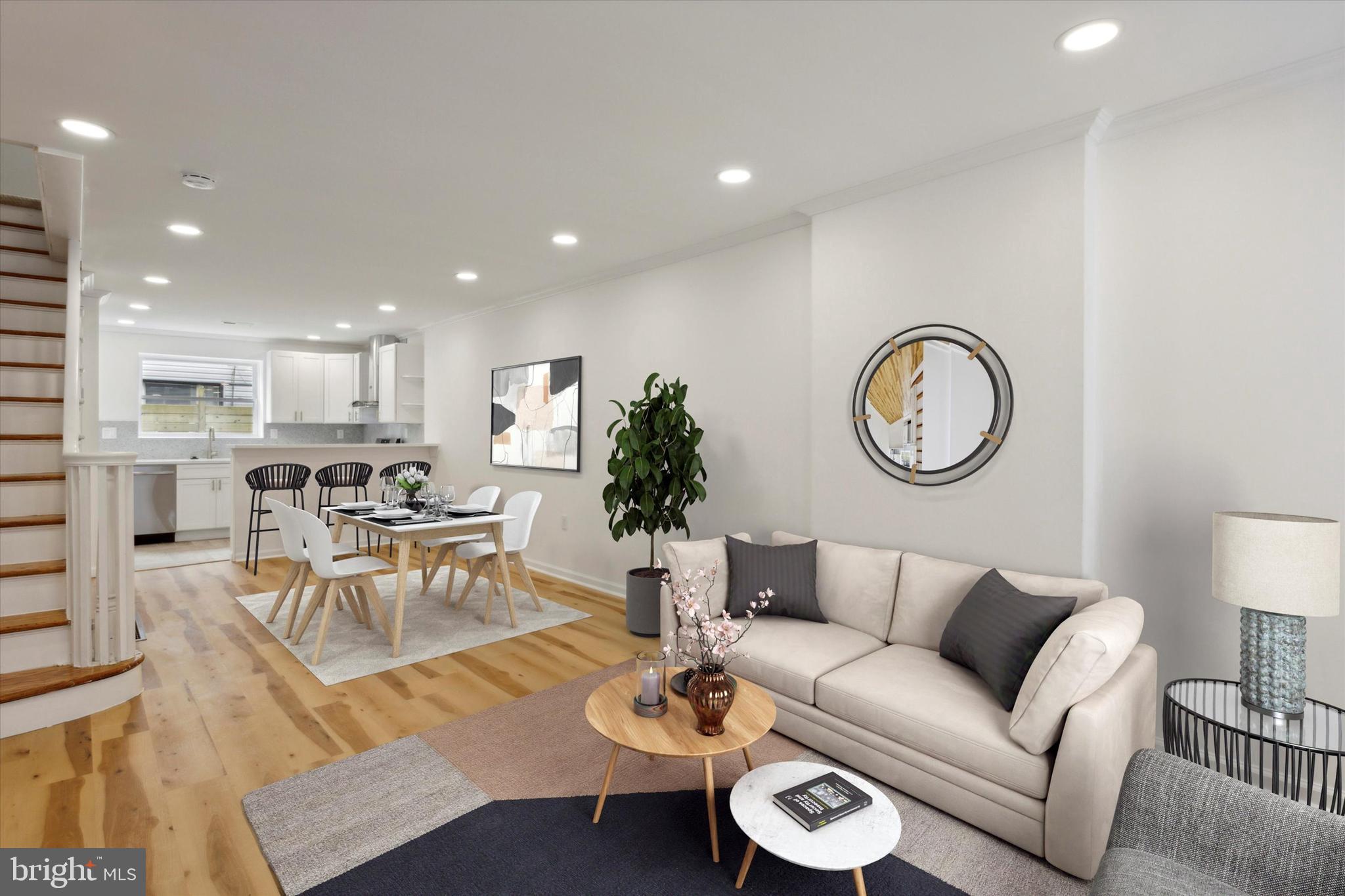 a living room with furniture kitchen view and a potted plant