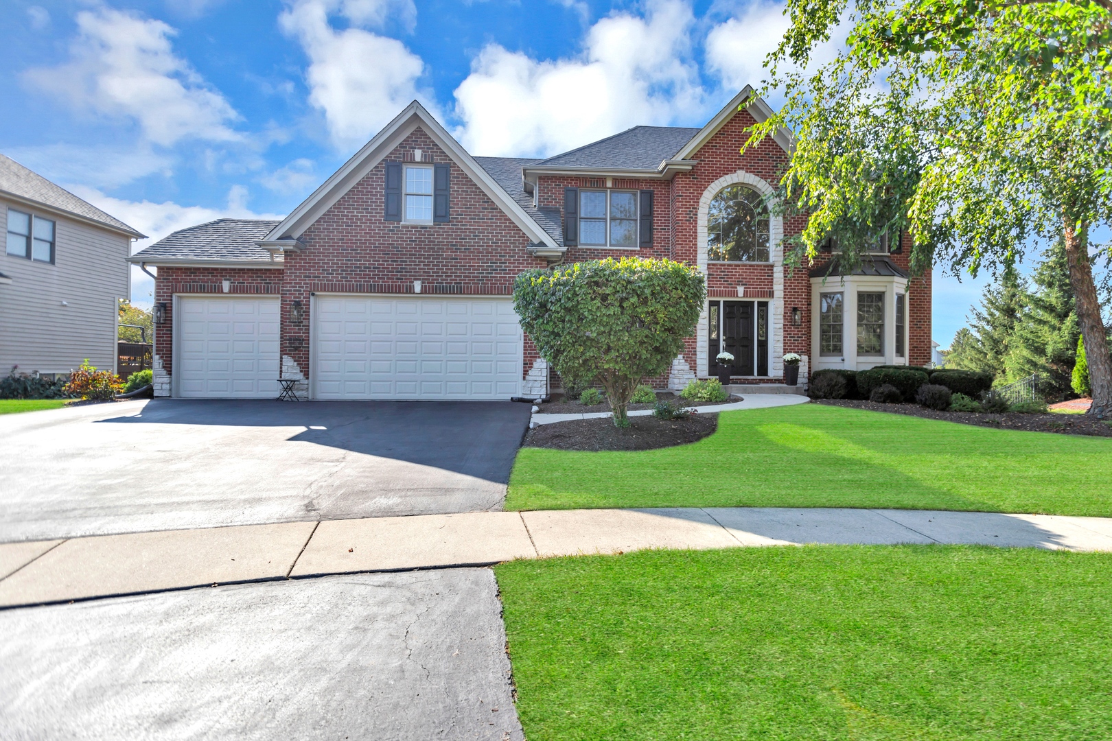 a front view of a house with a yard and trees