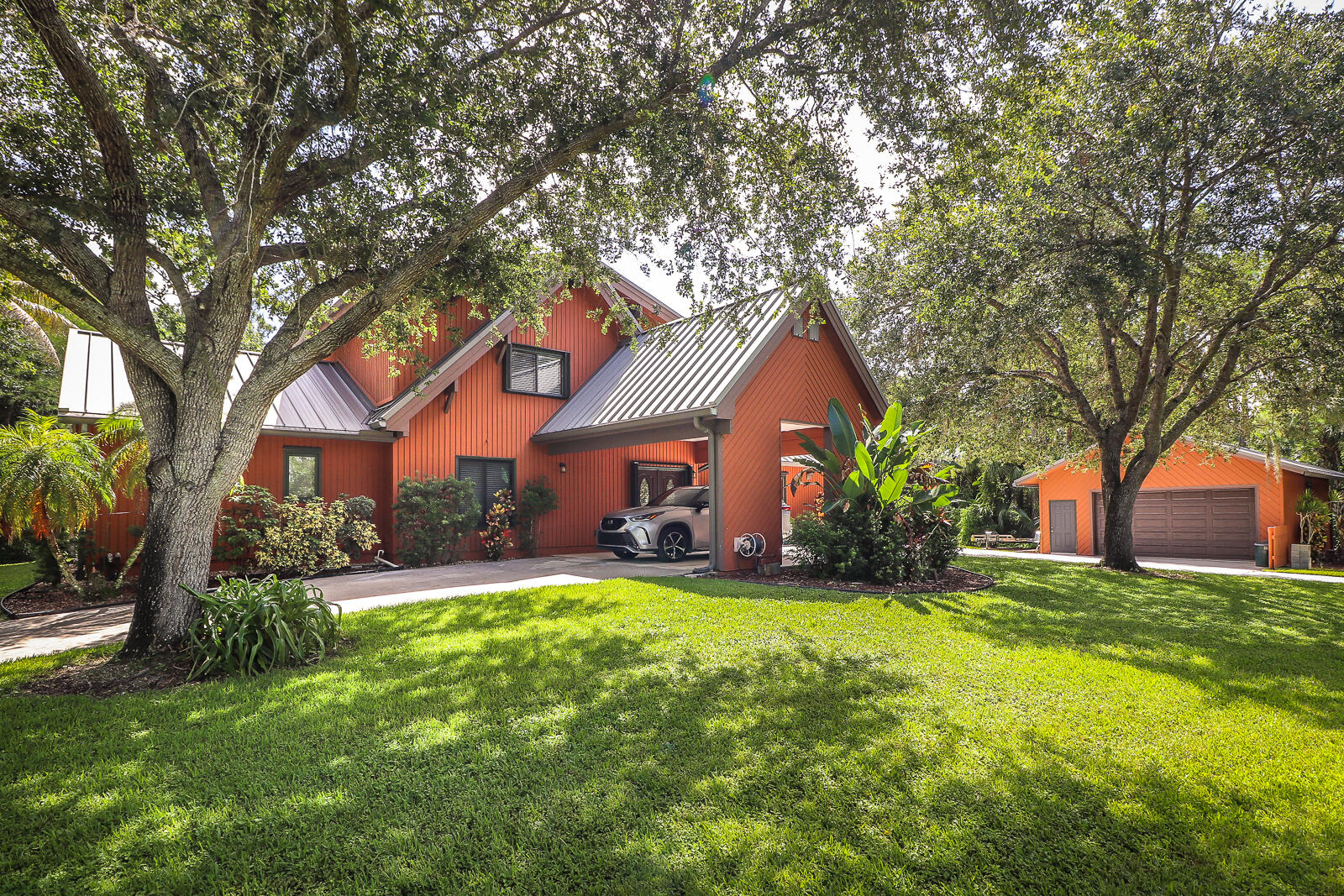 a front view of house with yard and tree in front of it