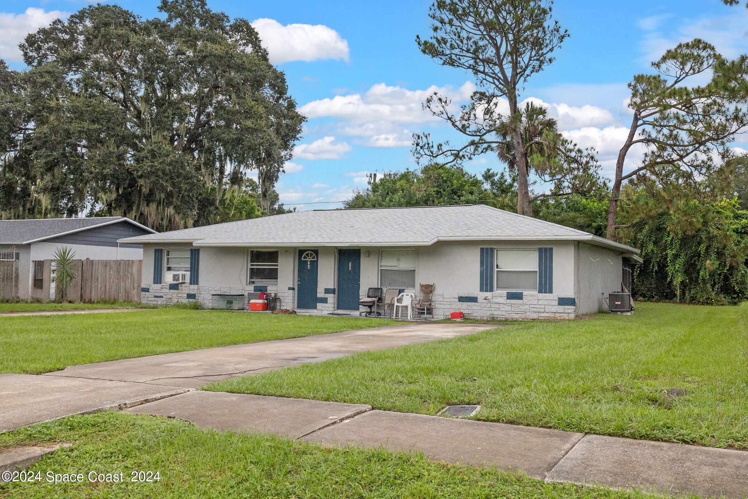 a front view of a house with a yard and trees