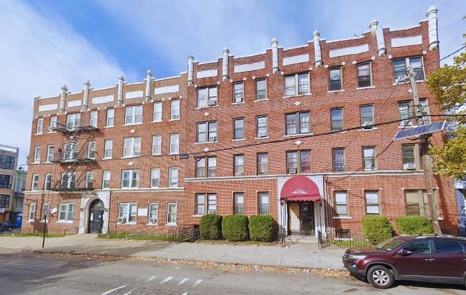 a front view of a residential apartment building with a yard