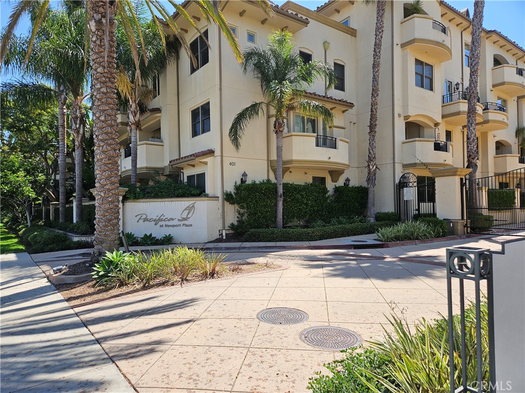 a front view of a multi story residential apartment building with yard and traffic signal