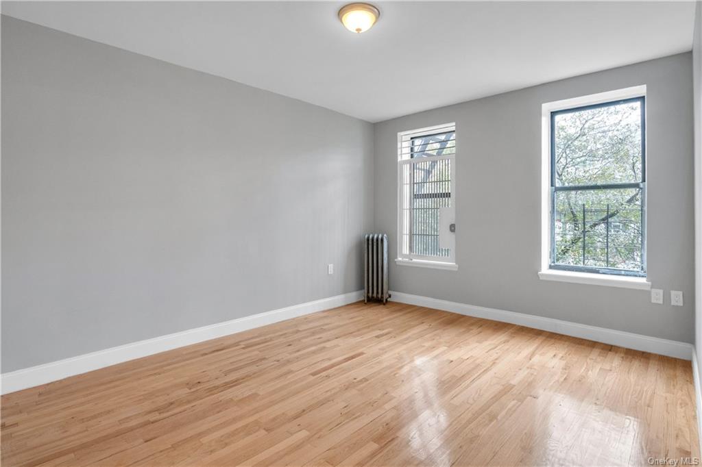 Empty room featuring light wood-type flooring and radiator