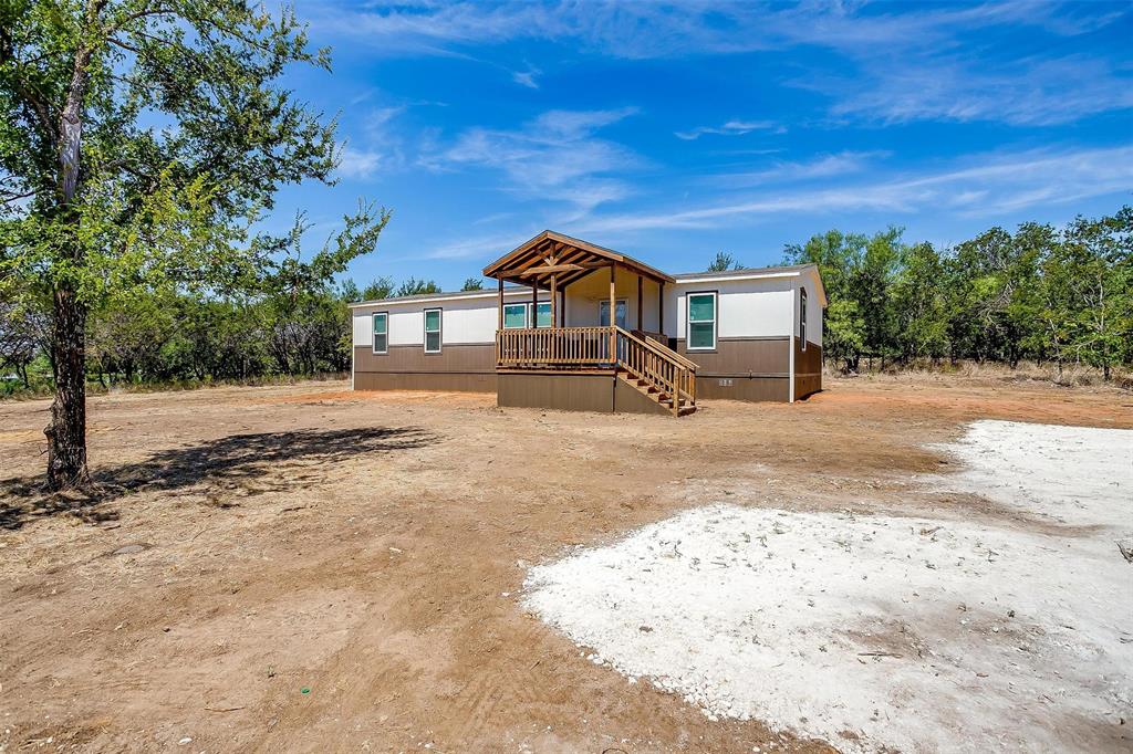 a dirt road with a building in the background