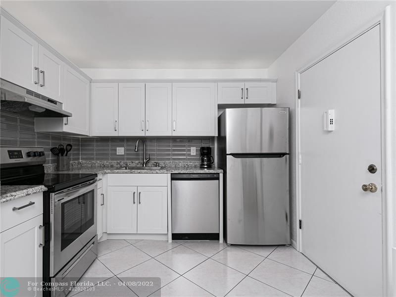 a kitchen with stainless steel appliances granite countertop a refrigerator and a stove top oven