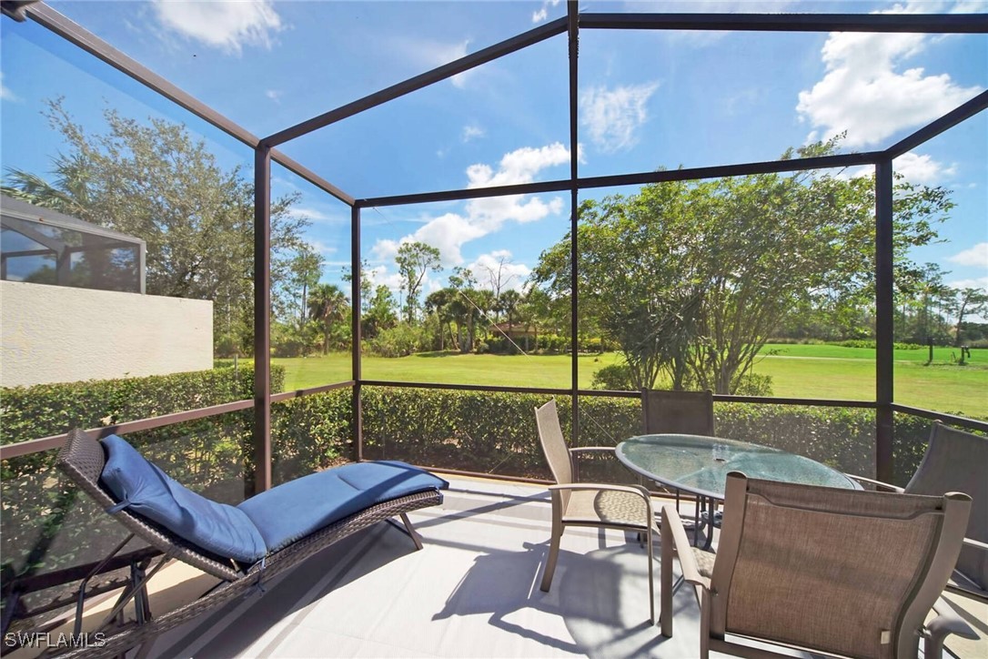 a view of a patio with a table chairs and a floor to ceiling window