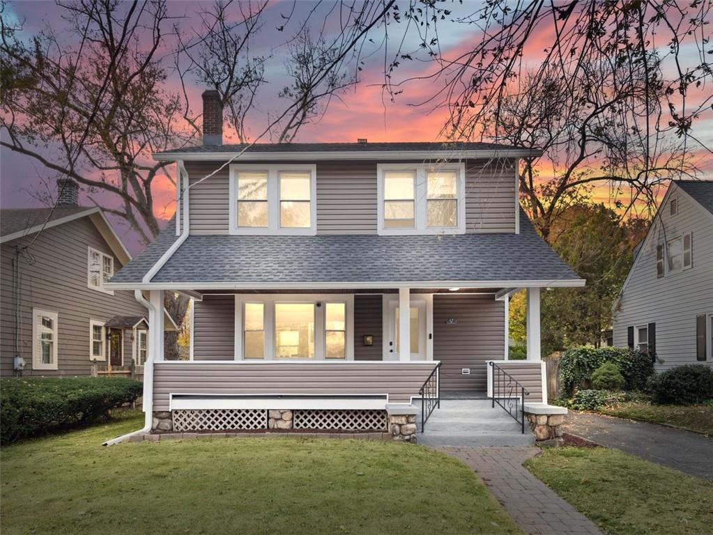 View of front of house with covered porch and a yard