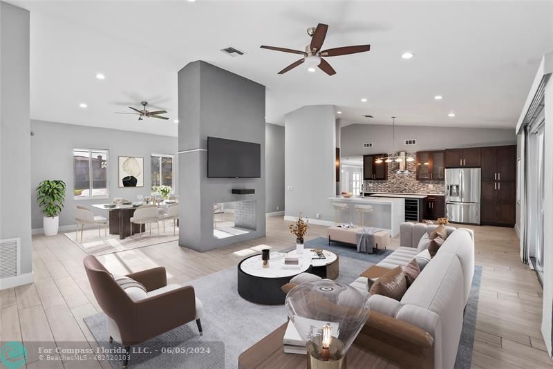 a living room with furniture kitchen view and a flat screen tv