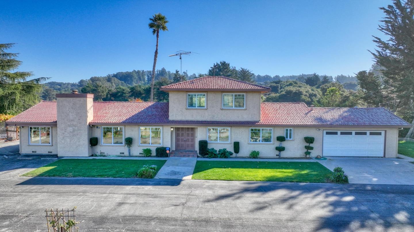 a view of a house with a yard and palm tree