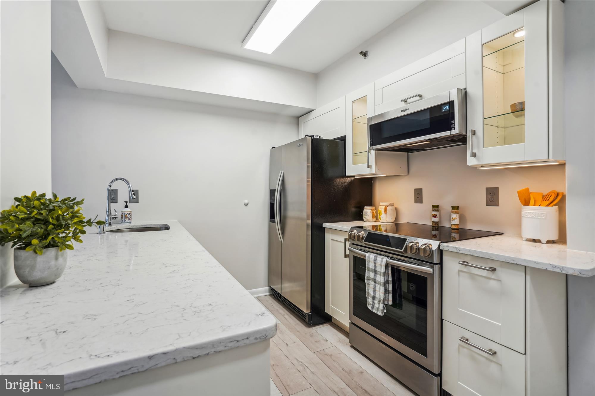 a kitchen with stainless steel appliances a stove a sink a microwave and cabinets