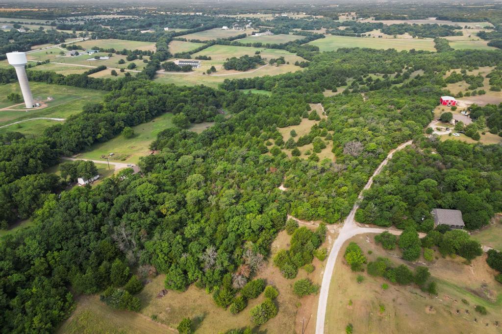 an aerial view of residential houses with outdoor space and trees