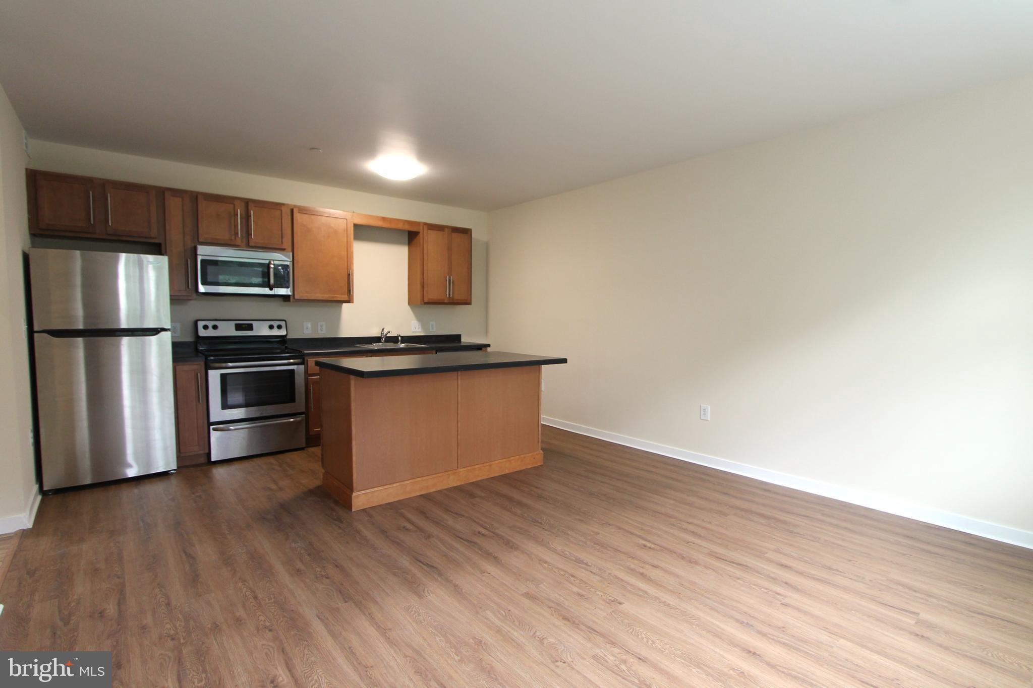 a kitchen with wooden floors and stainless steel appliances