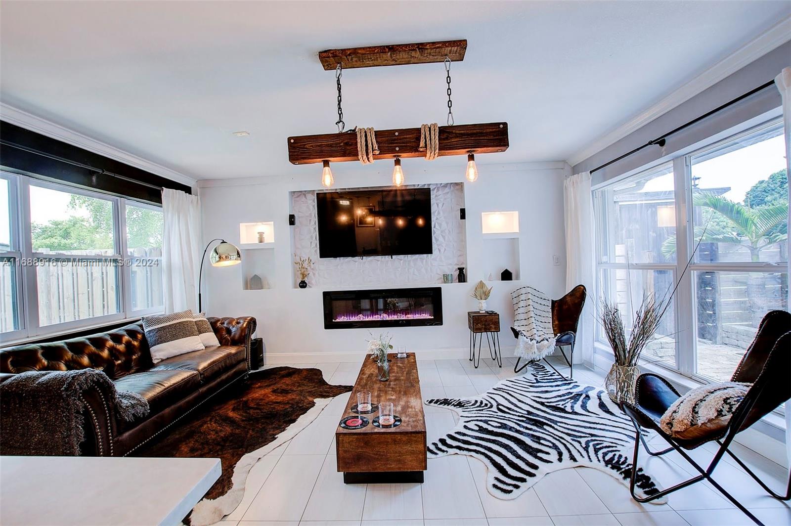 a living room with furniture fireplace and a large window