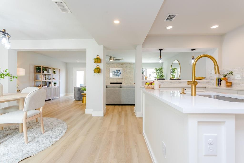 a kitchen with sink a refrigerator and chairs