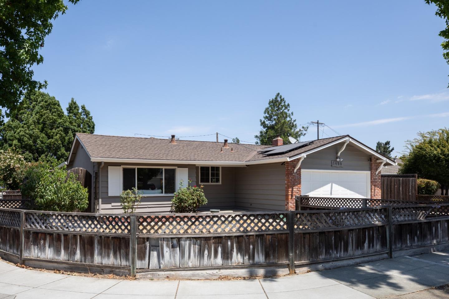 a front view of a house with a garden and plants