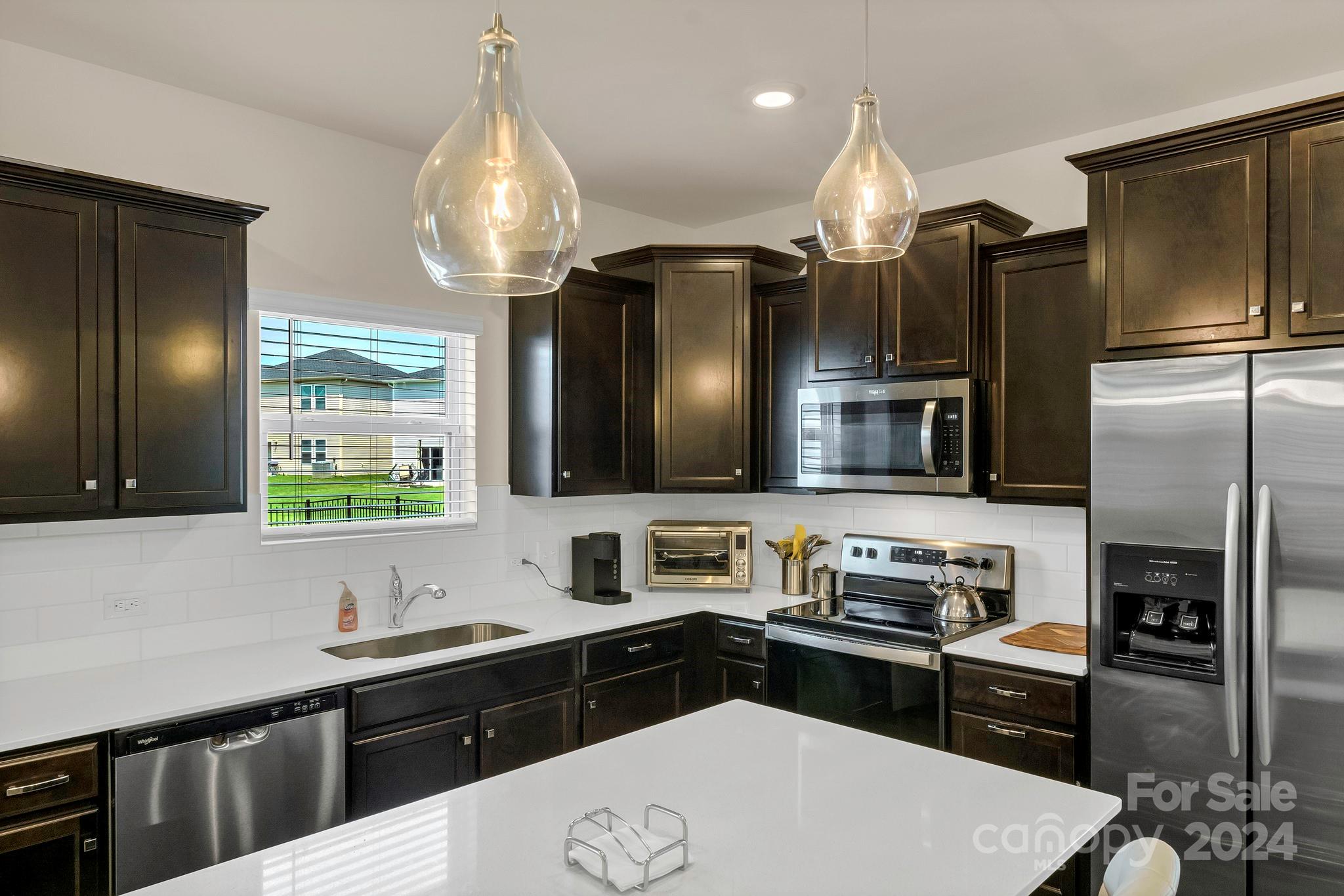 a kitchen with stainless steel appliances a sink stove and refrigerator