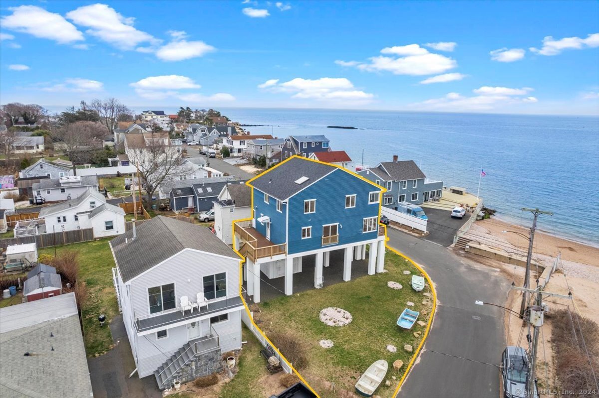 an aerial view of residential houses with outdoor space and parking