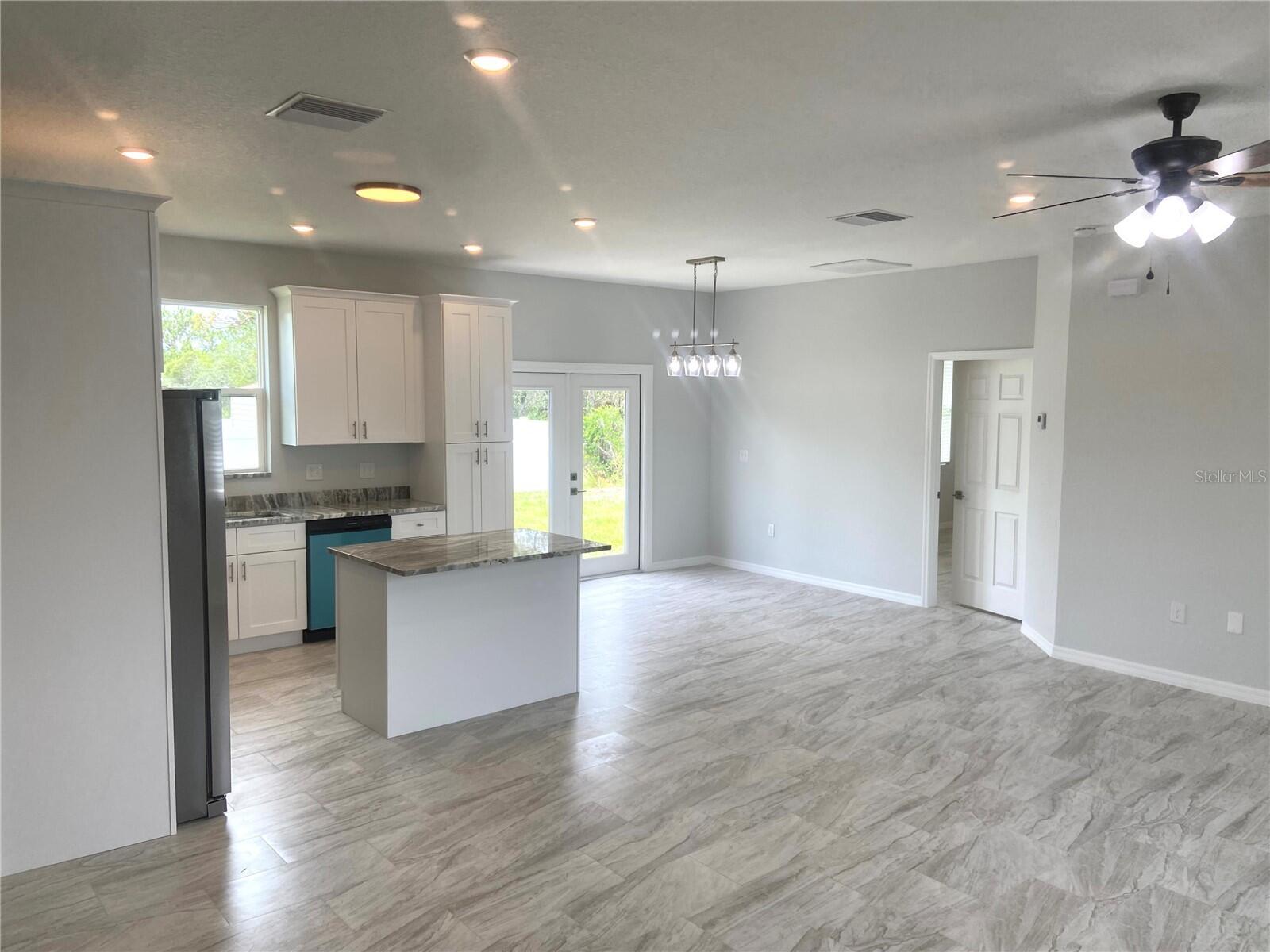 a view of kitchen with kitchen island white cabinets and stainless steel appliances