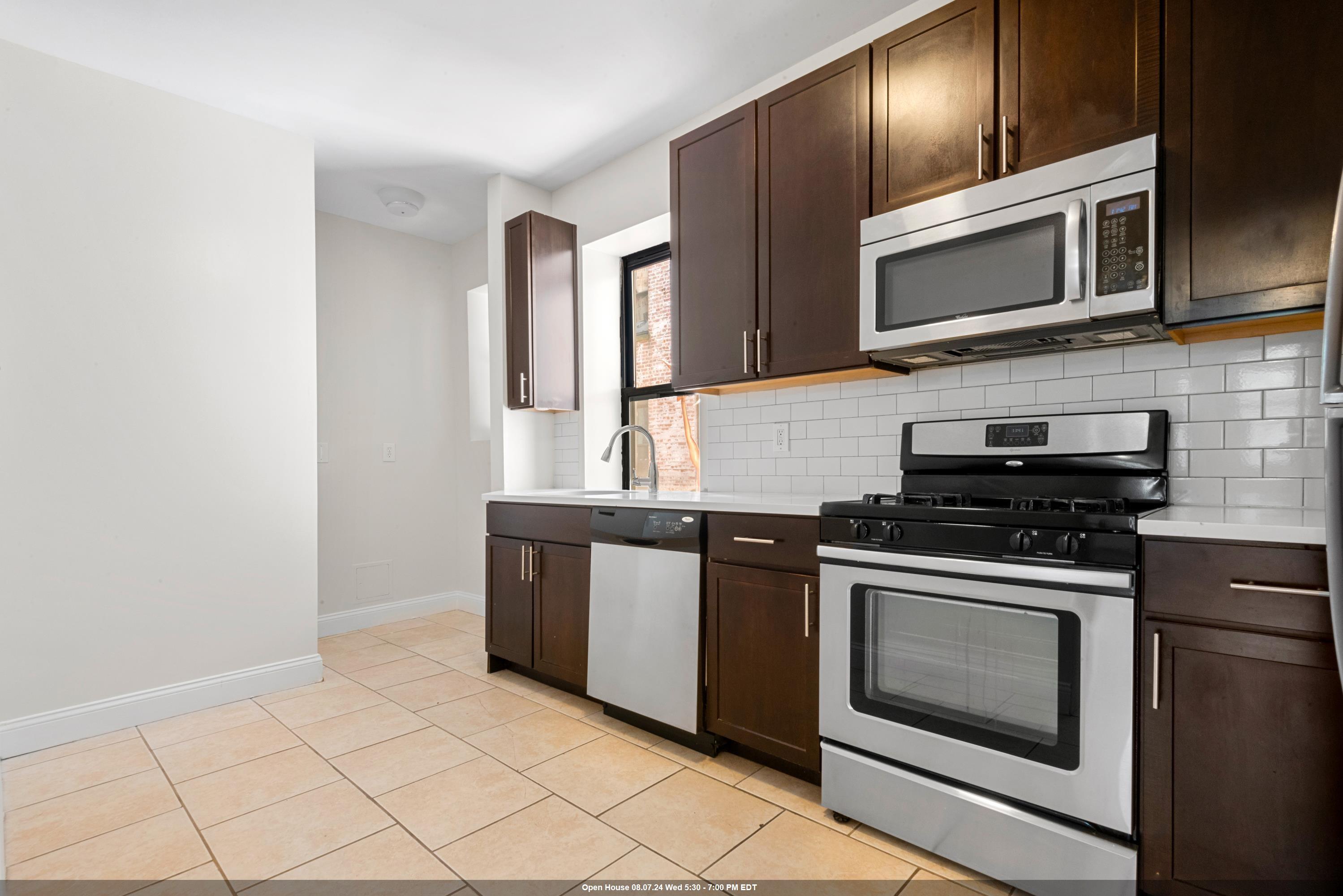 a kitchen with granite countertop cabinets stainless steel appliances and wooden cabinets