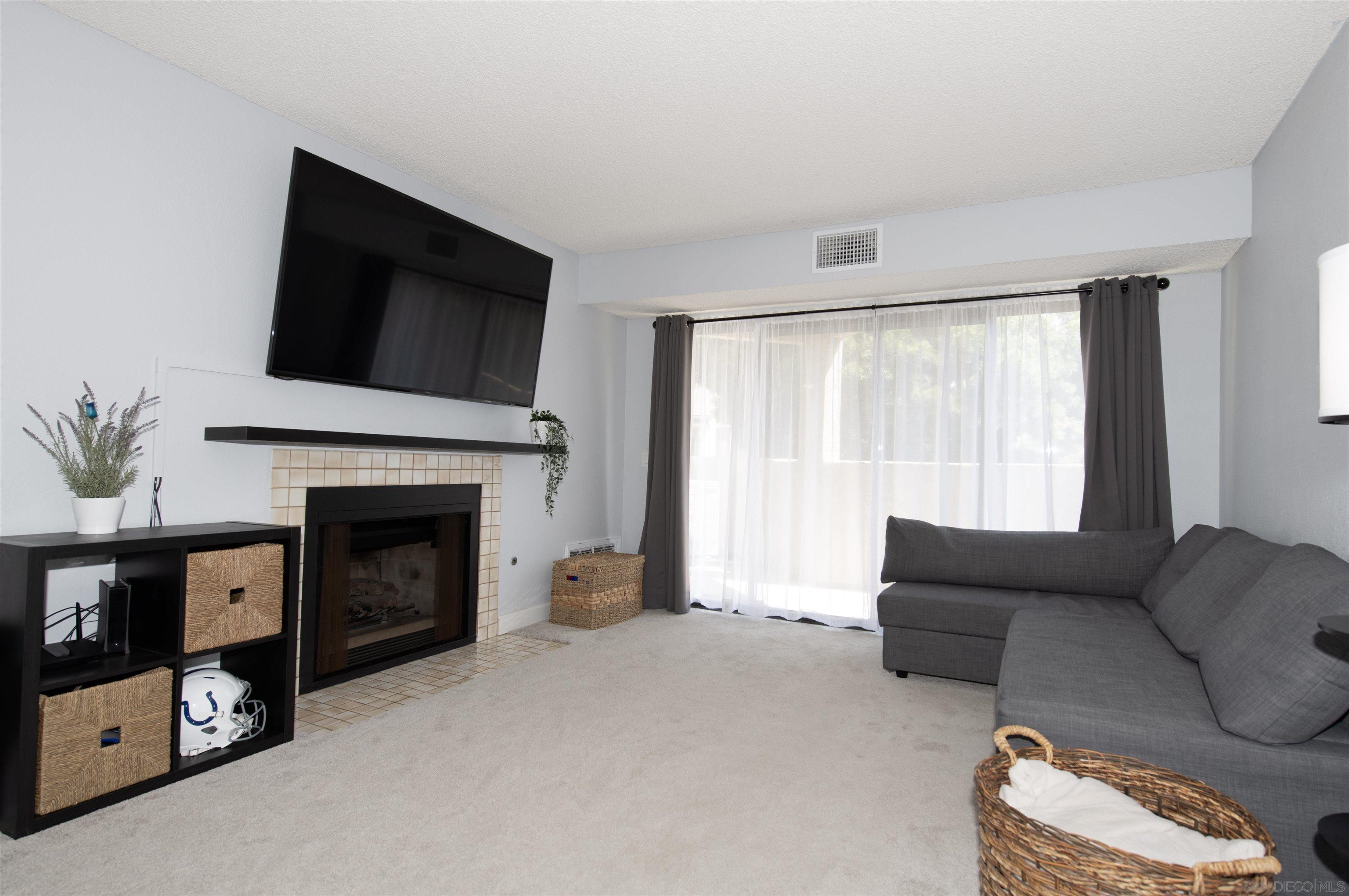 a living room with furniture a flat screen tv and a fireplace