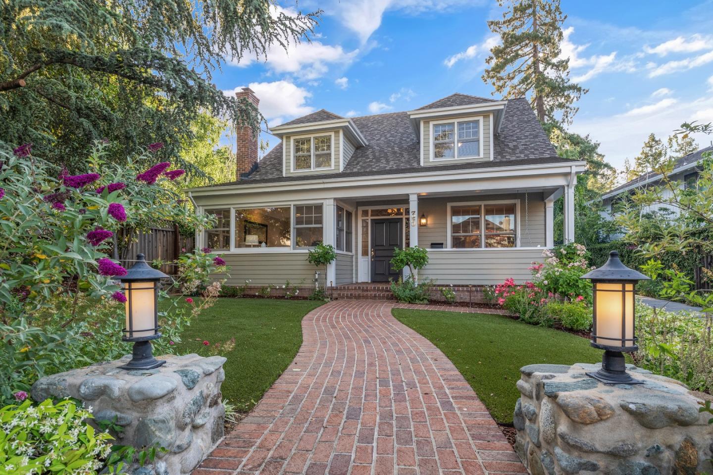 a front view of a house with a yard and potted plants