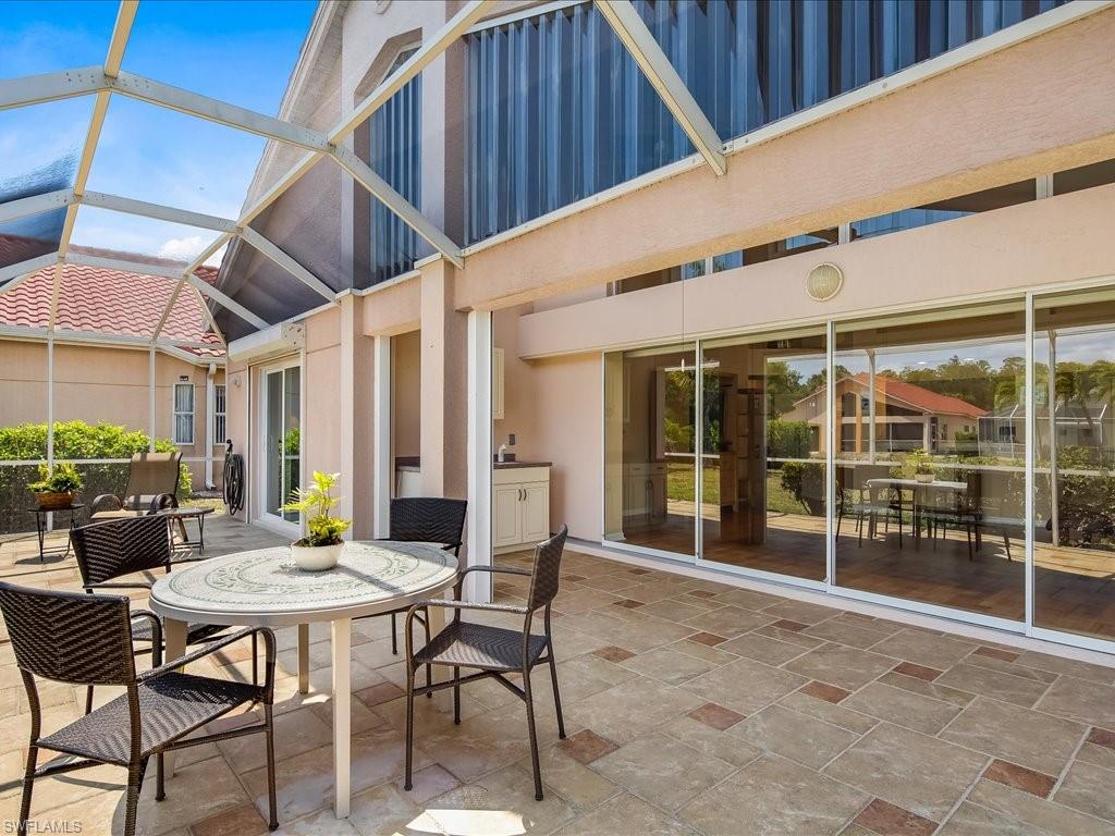 a view of a patio with a table and chairs and potted plants