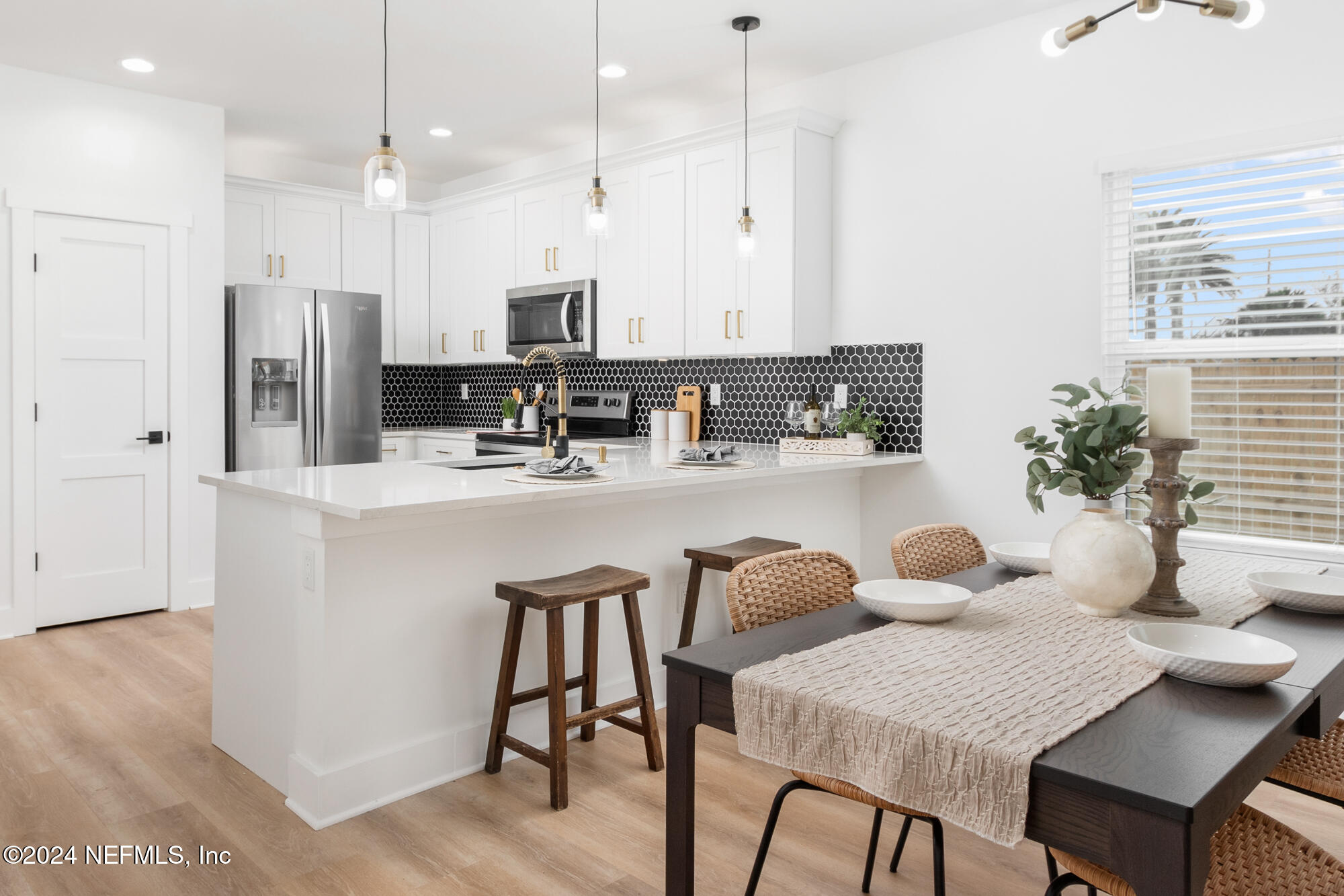 a kitchen with a table chairs refrigerator and microwave