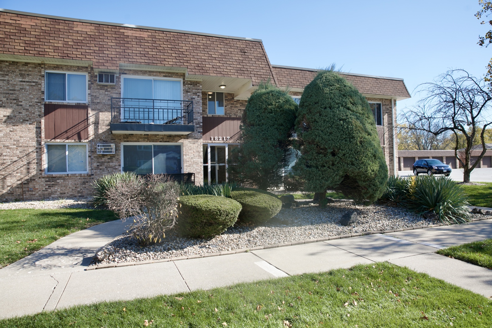 a view of a brick house with a yard and plants