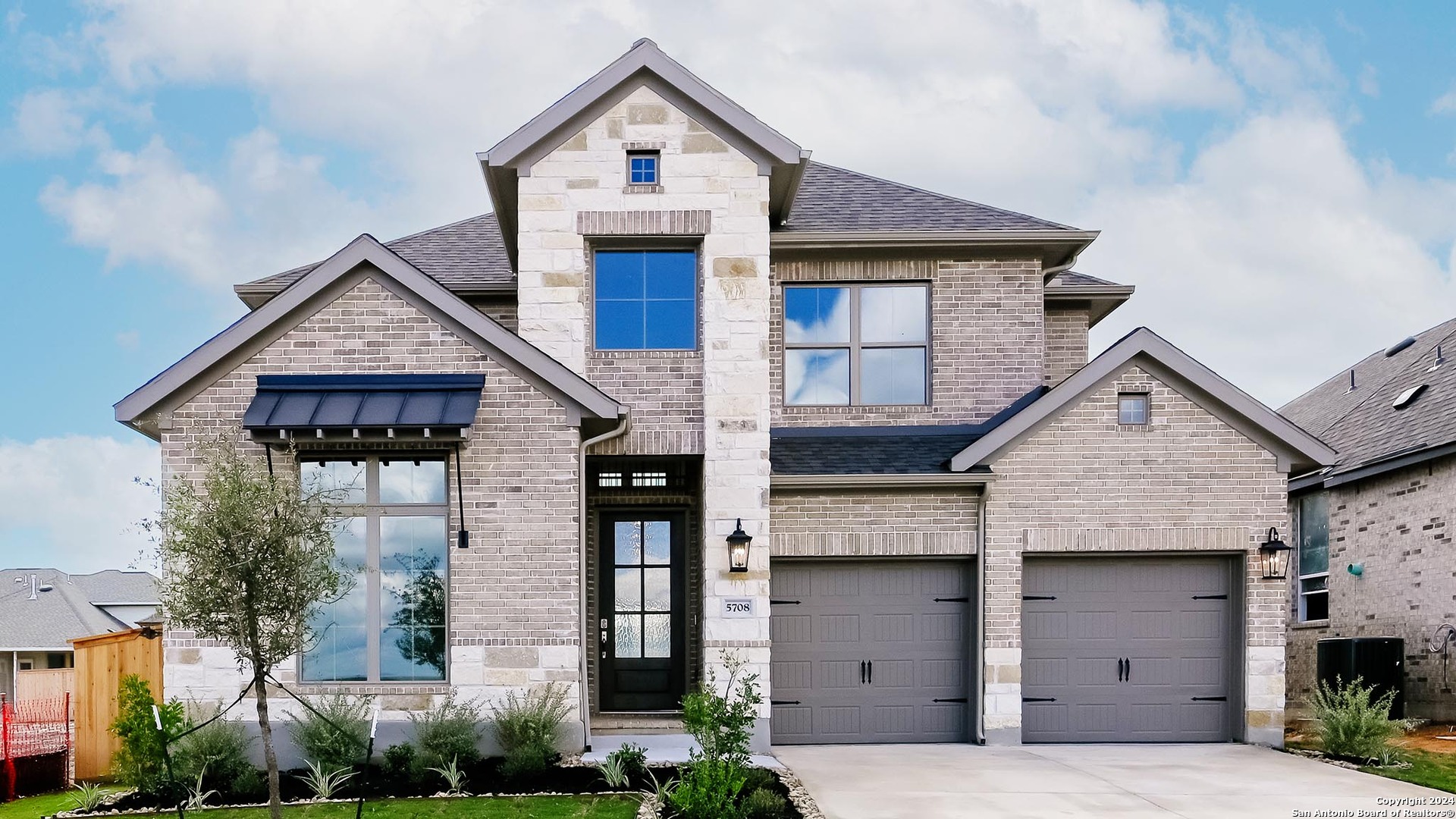 a front view of a house with a yard and garage