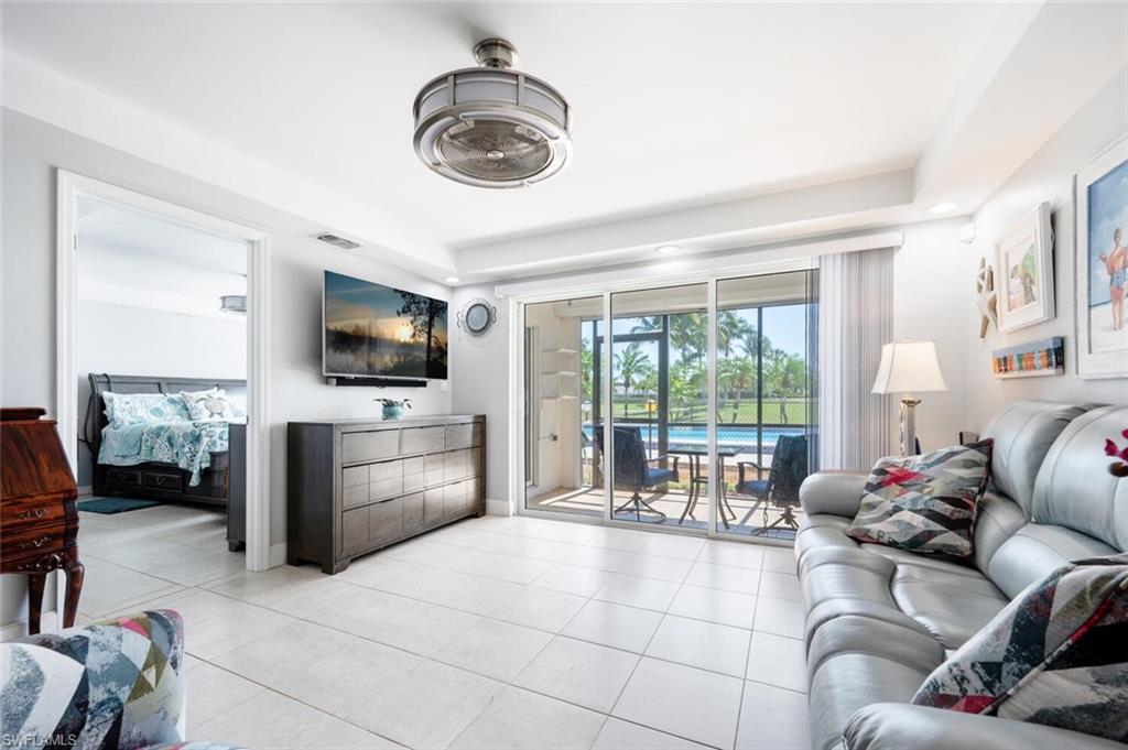 a living room with furniture a flat screen tv and a large window