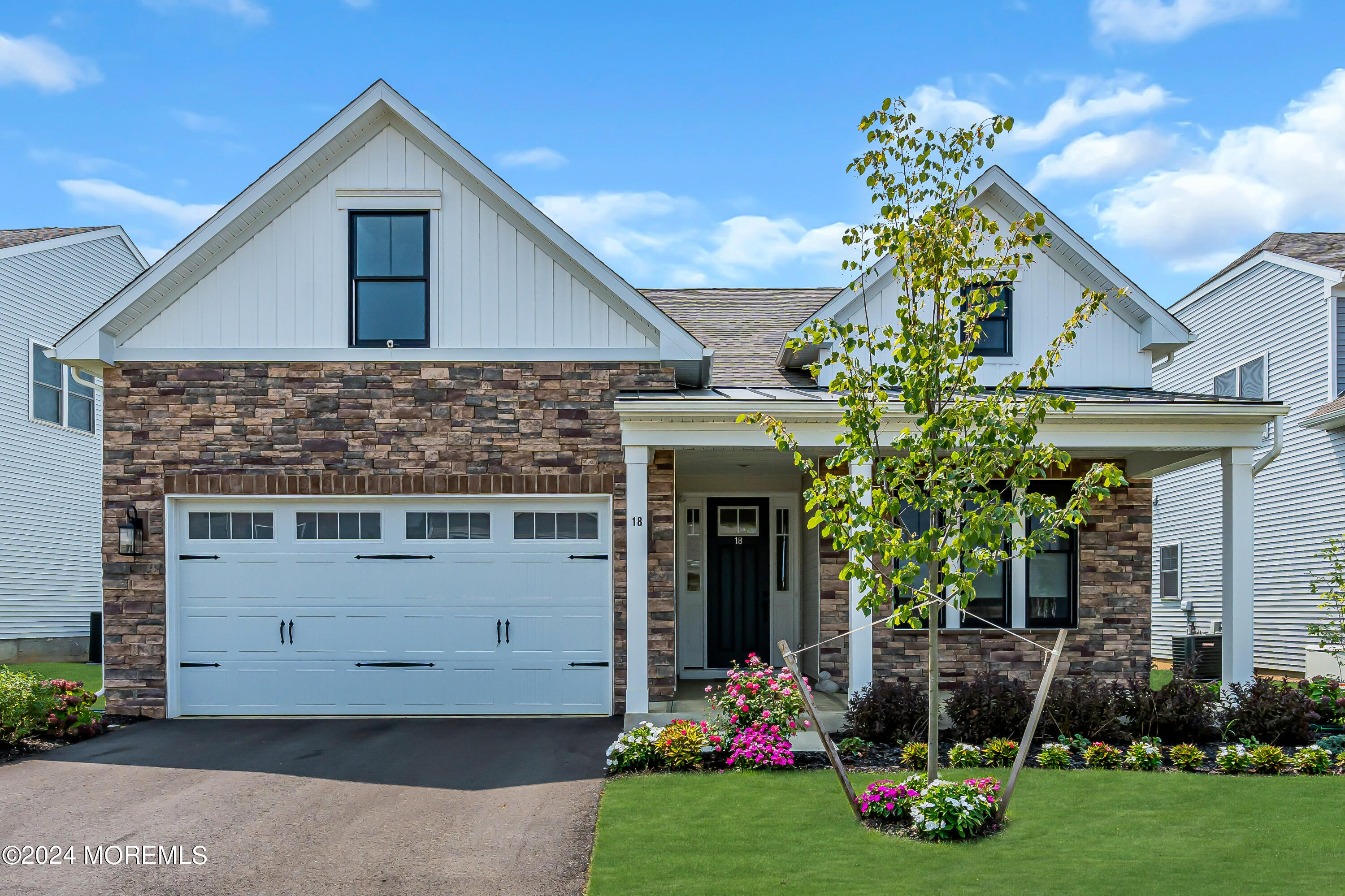 a front view of a house with a yard and potted plants