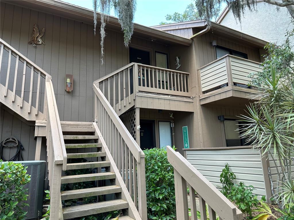 a view of house with wooden deck and furniture