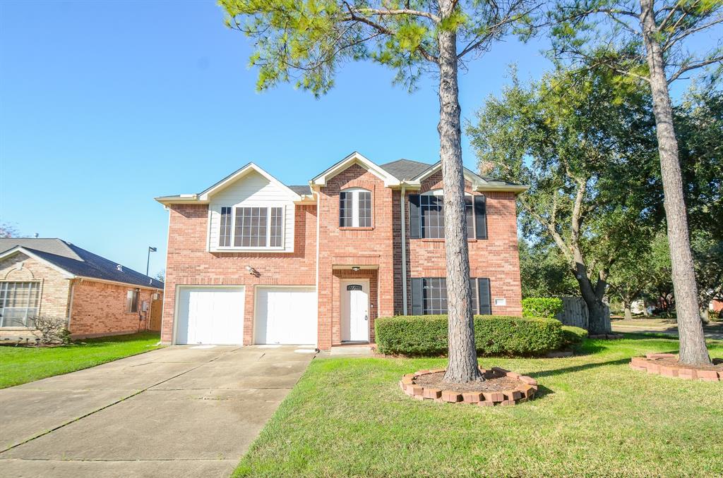 a front view of a house with a yard and trees