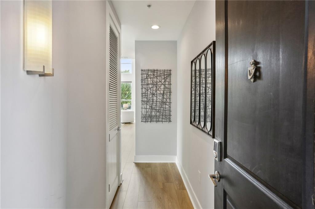 a view of a hallway with wooden floor and staircase