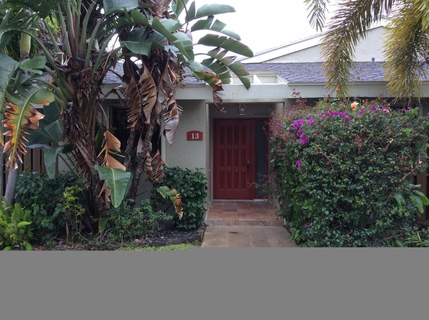 a view of a house with a tree and flower plants