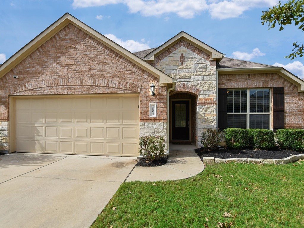 a front view of a house with a yard and garage