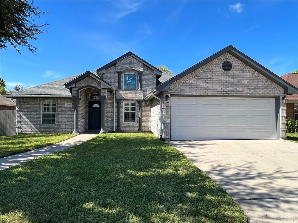 View of front of property with a front yard and a garage