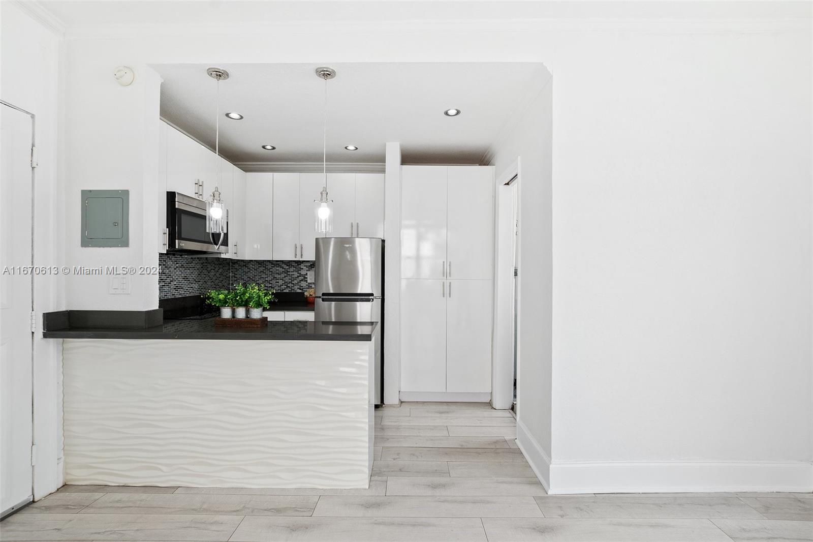 a view of a hallway with stainless steel appliances