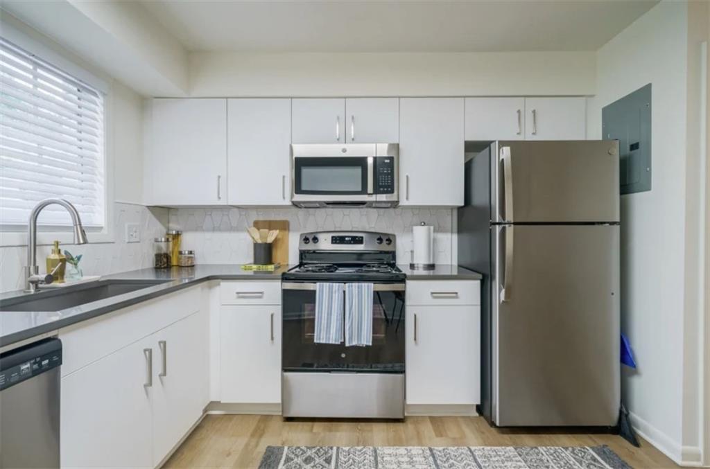 a kitchen with white cabinets and stainless steel appliances