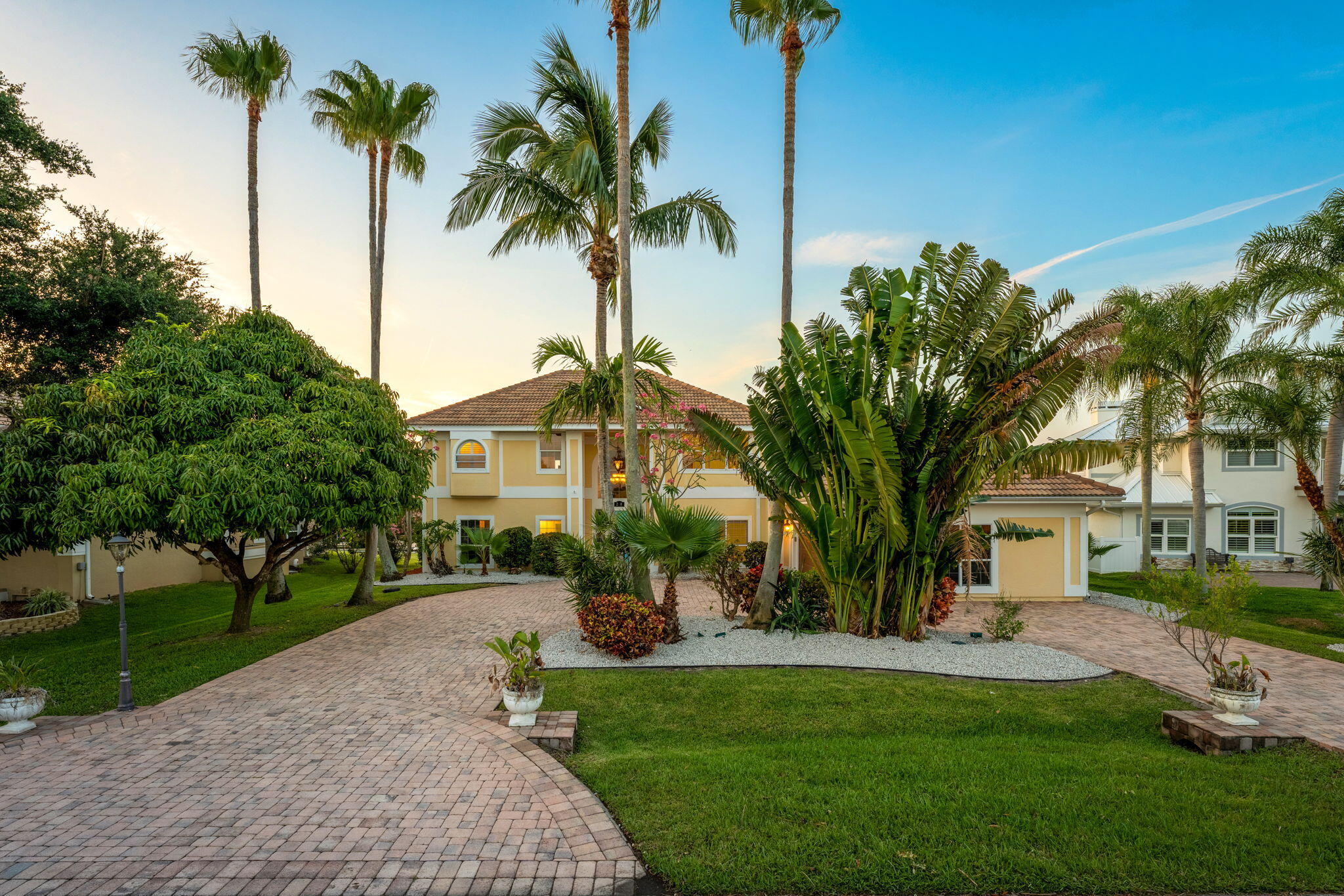 a front view of a house with garden and trees