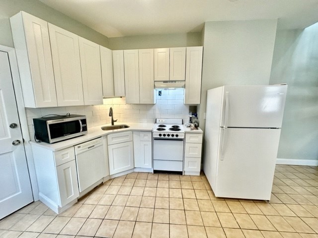 a kitchen with a refrigerator sink and cabinets