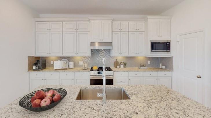 a kitchen with stainless steel appliances granite countertop a stove a sink and a granite counter tops