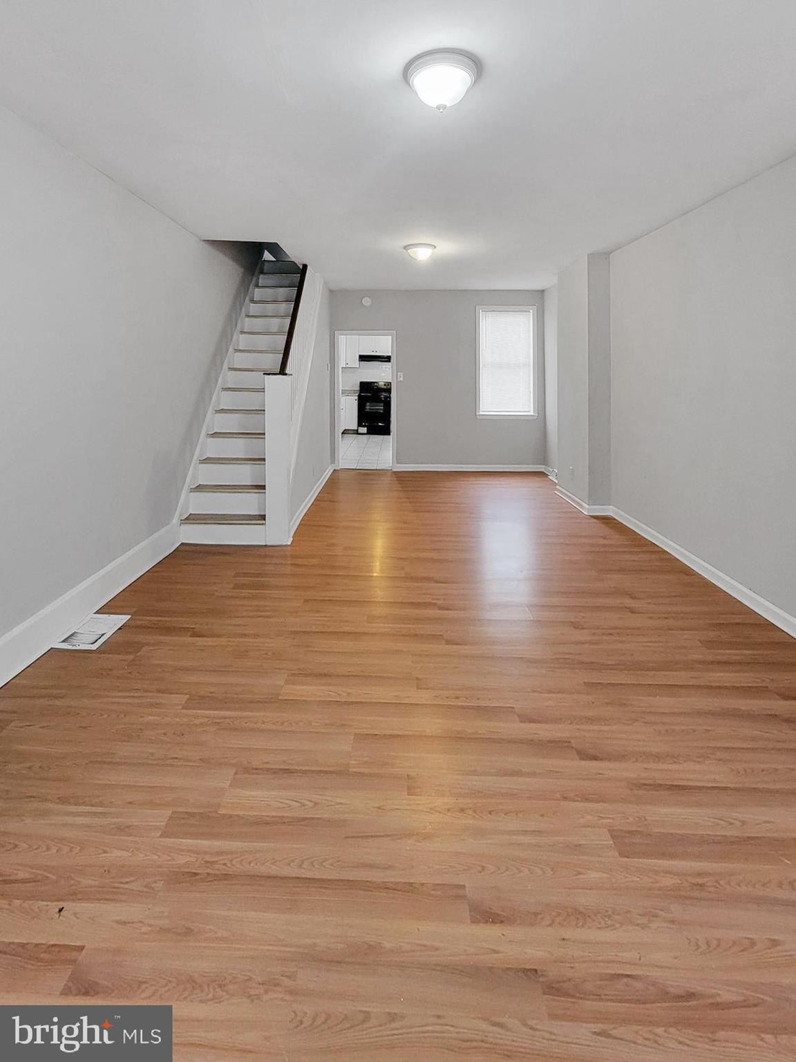 a view of room and hall with wooden floor