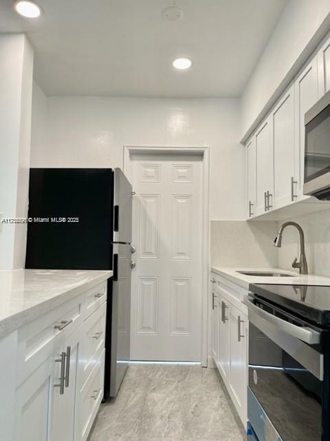 a view of cabinets with stainless steel appliances granite countertop white cabinets and sink