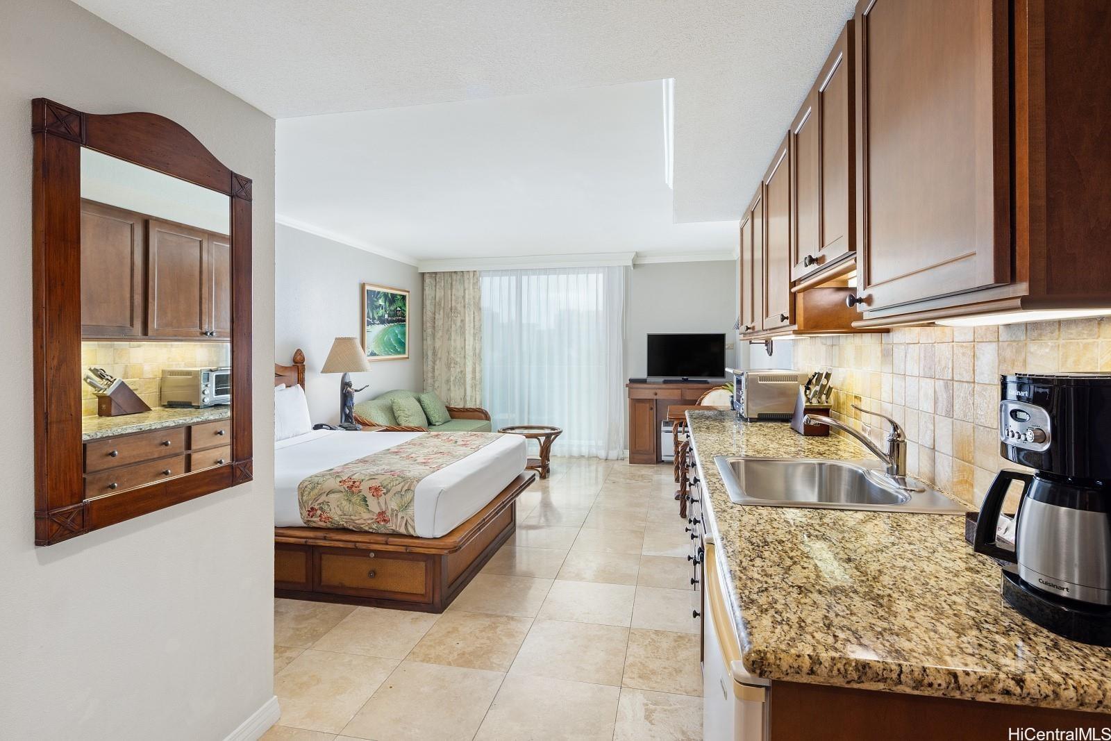 a living room with granite countertop couches a flat tv screen and a coffee table