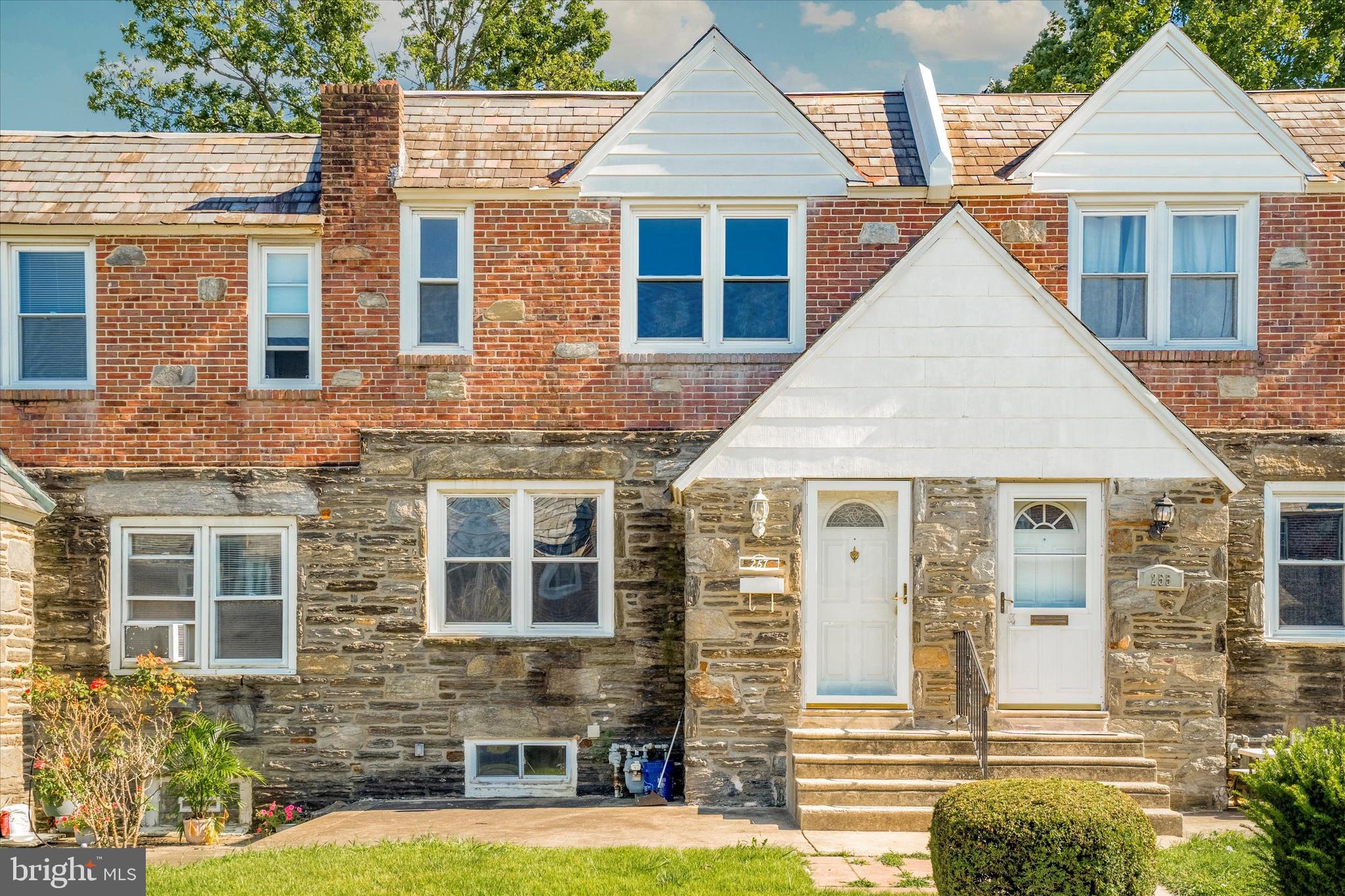 a view of a brick house with many windows next to a yard