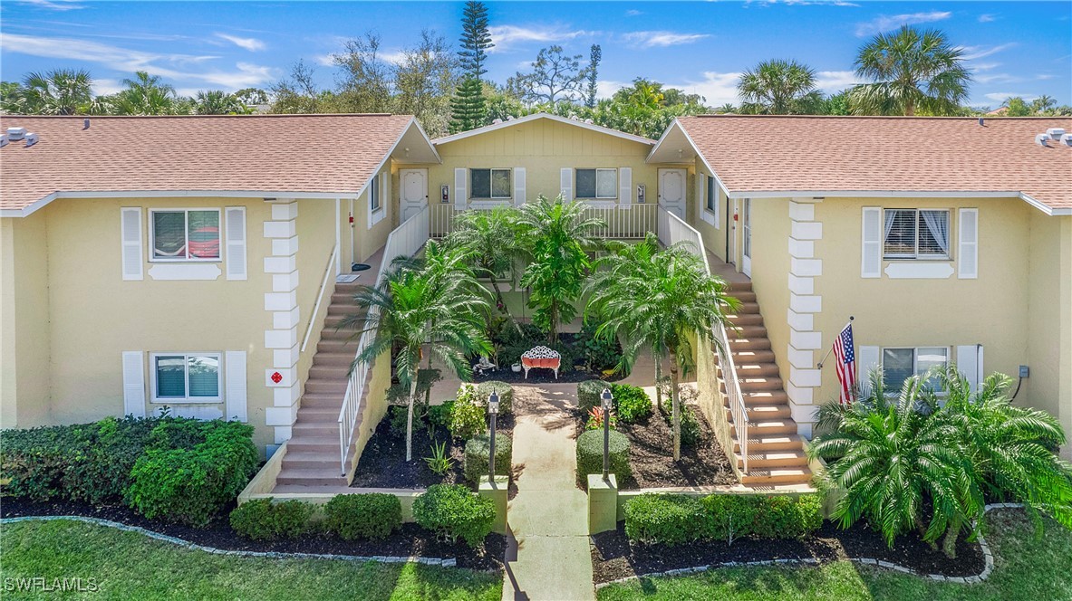 front view of house with a yard and potted plants