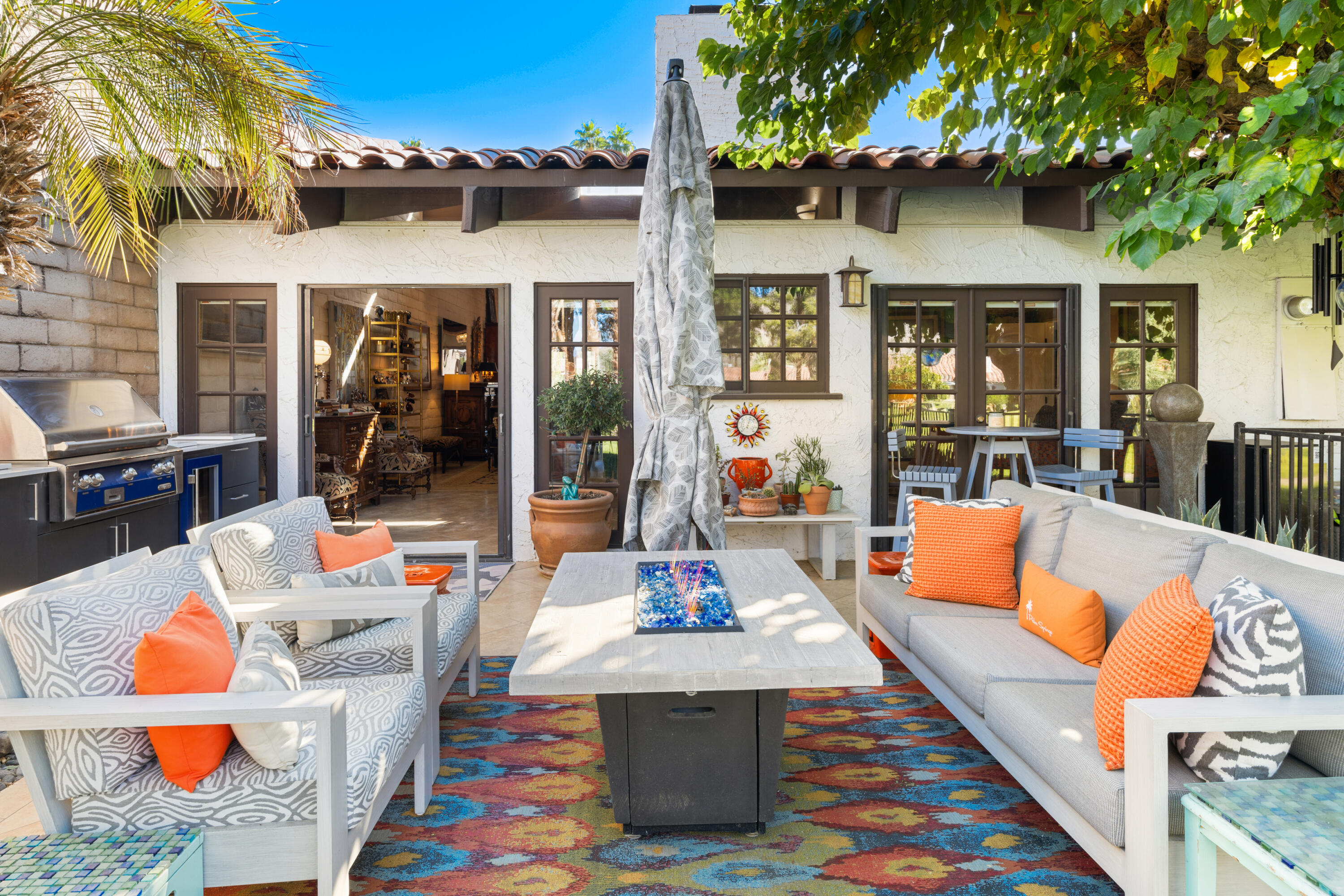 a outdoor space with the couches and dining table with the potted plants